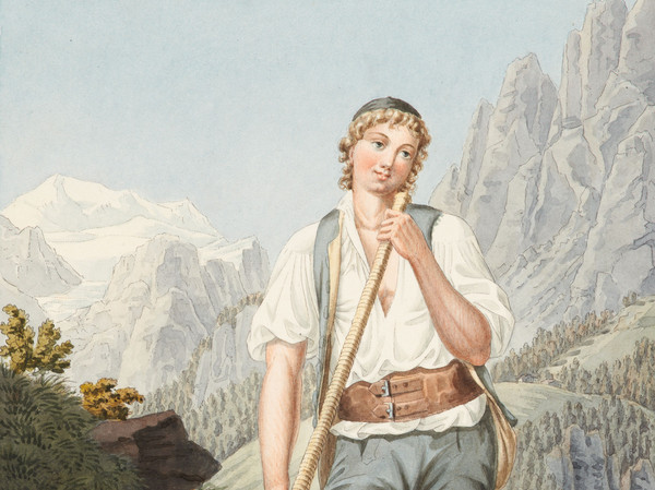 Giovane pastore con corno alpino, ritto su una roccia